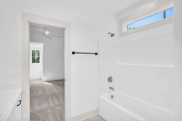 bathroom with ceiling fan, baseboards, vanity, and shower / bathing tub combination