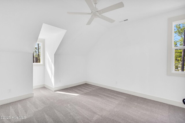 bonus room featuring vaulted ceiling, carpet flooring, visible vents, and plenty of natural light