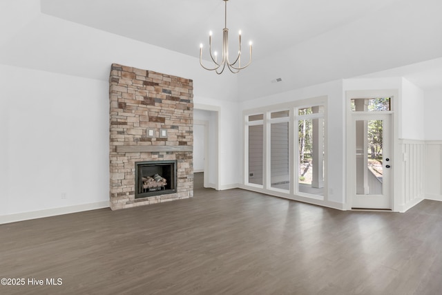 unfurnished living room featuring a chandelier, a fireplace, dark wood-style floors, and visible vents