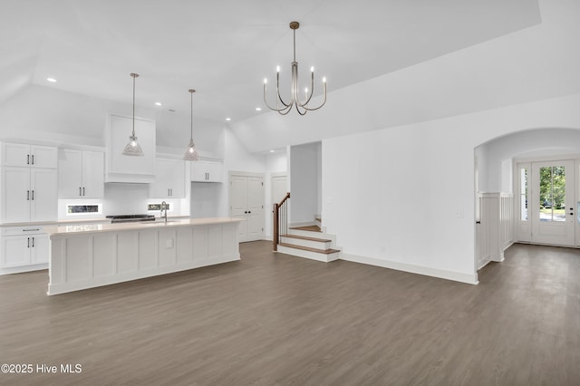 kitchen with recessed lighting, arched walkways, a spacious island, dark wood-style flooring, and white cabinetry