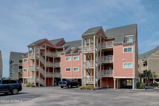 1000 Caswell Beach Rd Unit 1111, Oak Island, NC 28465 - view of apartment building / complex featuring uncovered parking