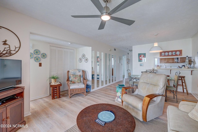 1000 Caswell Beach Rd Unit 1111, Oak Island, NC 28465 - living area with light wood finished floors, a ceiling fan, and baseboards