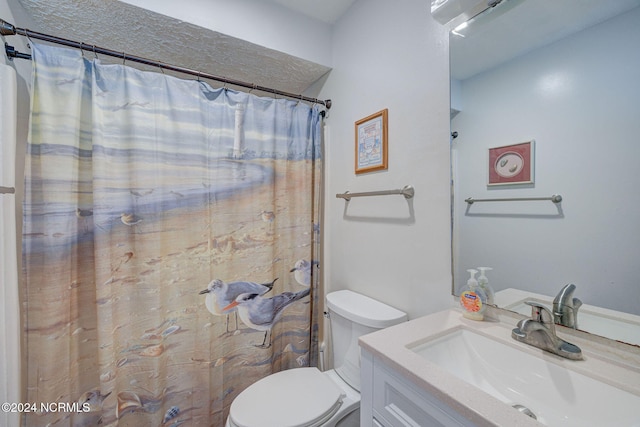 bathroom with vanity, curtained shower, and toilet