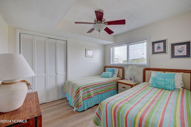 1000 Caswell Beach Rd Unit 1111, Oak Island, NC 28465 - bedroom with light wood-type flooring, a textured ceiling, a closet, and ceiling fan