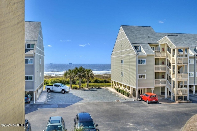 view of property with a water view and a beach view