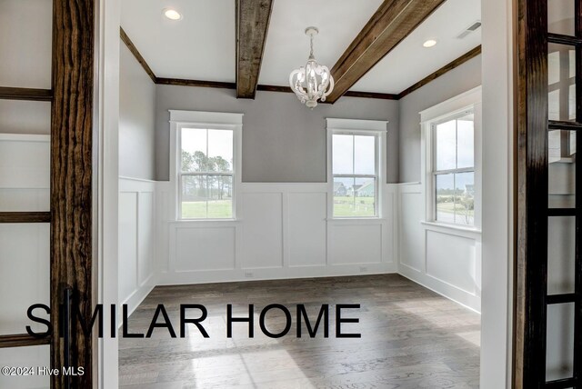 spare room featuring wood-type flooring and crown molding