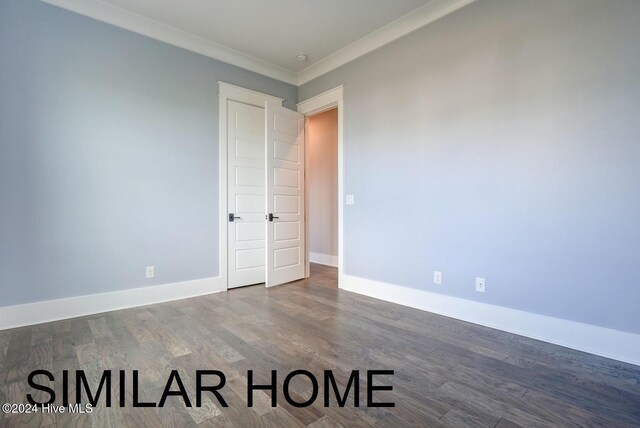 unfurnished bedroom with dark hardwood / wood-style floors, a closet, and crown molding