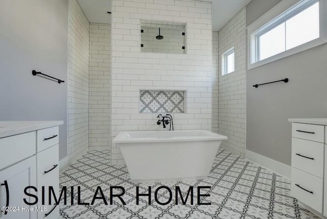 187 Spicer Lake Dr, Holly Ridge, NC 28445 - bathroom with vanity, tile walls, baseboards, a freestanding bath, and a walk in shower