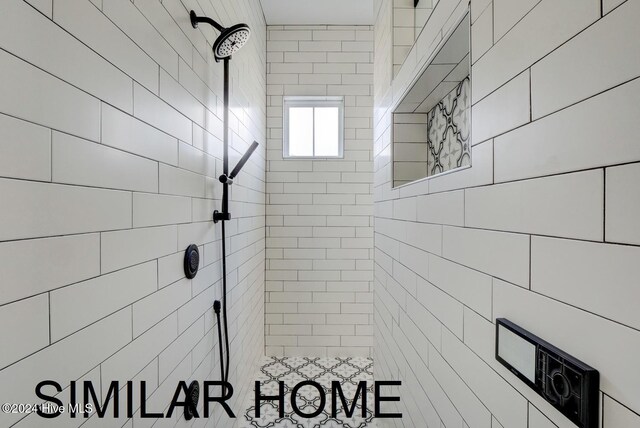 bathroom with baseboards, tile patterned floors, a freestanding bath, vanity, and tile walls