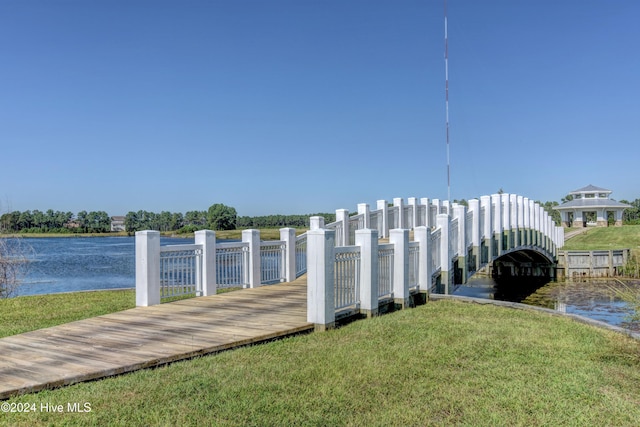 dock area with a water view and a yard