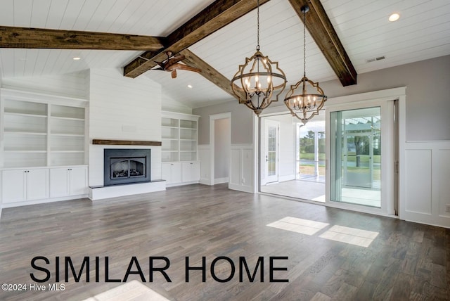187 Spicer Lake Dr, Holly Ridge, NC 28445 - unfurnished living room featuring an inviting chandelier, built in shelves, visible vents, a decorative wall, and vaulted ceiling with beams