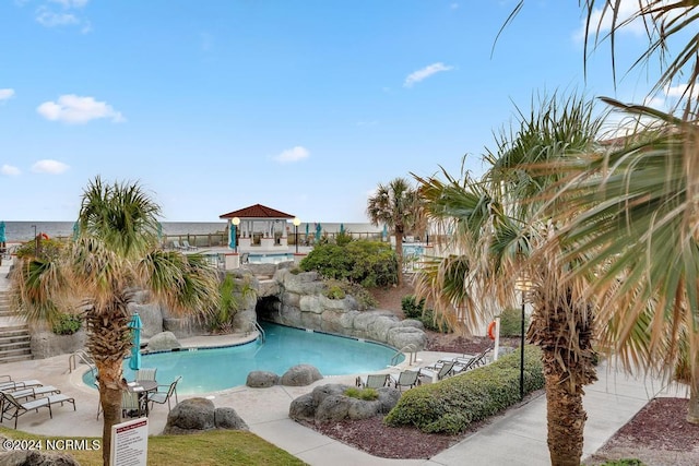 view of swimming pool with a gazebo and a water view