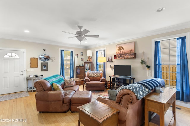 living room with ornamental molding, light hardwood / wood-style floors, and ceiling fan