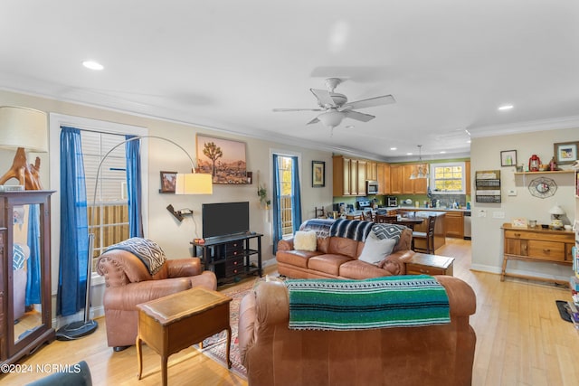 living room with ornamental molding, light hardwood / wood-style floors, and ceiling fan