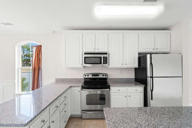 kitchen with white cabinetry, light stone counters, and stainless steel appliances