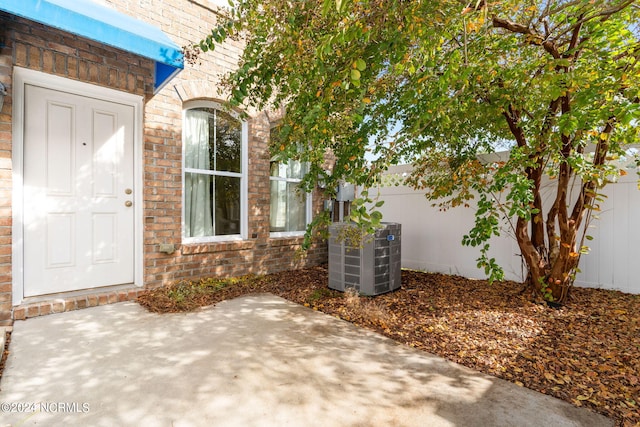 property entrance with a patio area and central AC unit