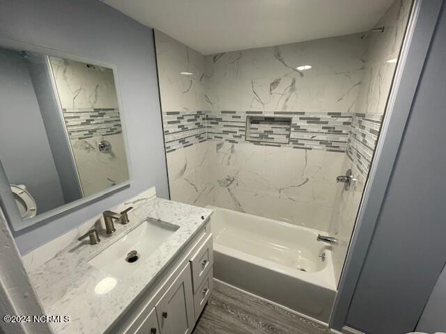 bathroom with vanity, hardwood / wood-style flooring, and tiled shower / bath combo