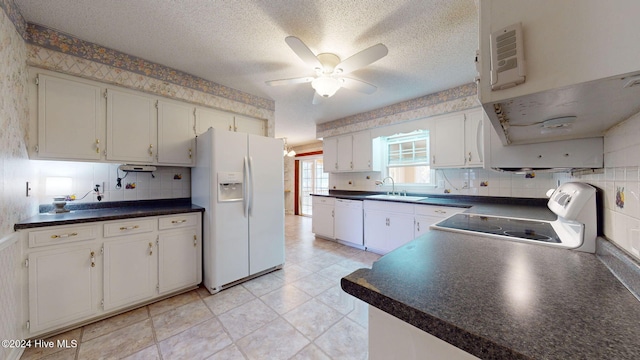 kitchen with white cabinetry, white appliances, sink, and a textured ceiling