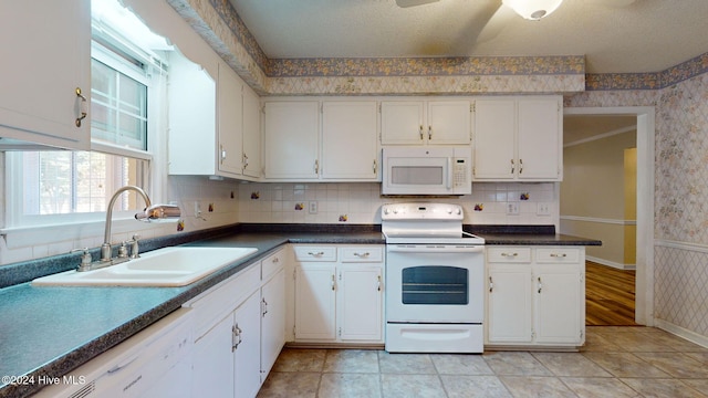 kitchen featuring sink, ceiling fan, light tile patterned floors, white appliances, and white cabinets