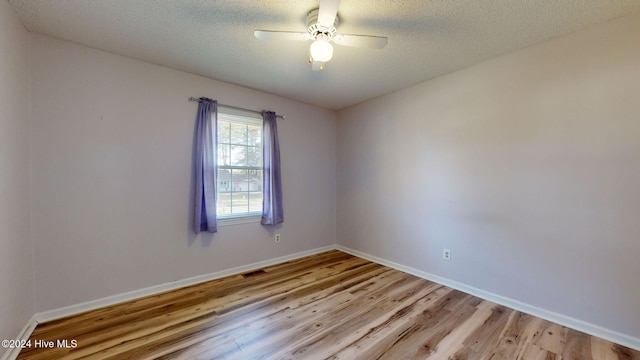 spare room with ceiling fan, a textured ceiling, and light hardwood / wood-style floors