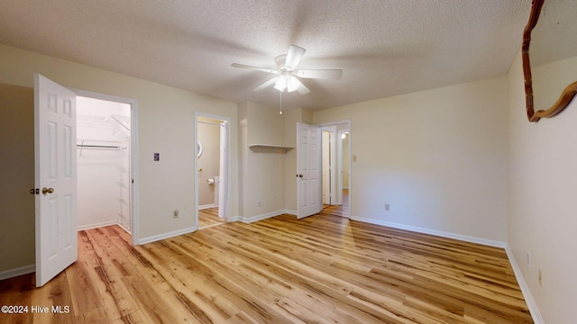 unfurnished bedroom featuring a textured ceiling, light hardwood / wood-style flooring, ceiling fan, and a closet