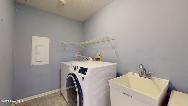 laundry room featuring electric panel, a textured ceiling, sink, and independent washer and dryer