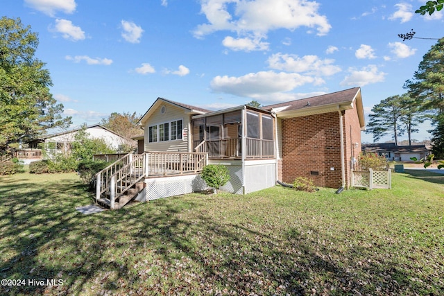 rear view of property featuring a sunroom, a yard, and a deck