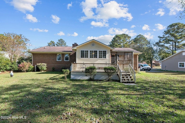 rear view of house with a sunroom, a yard, and a deck