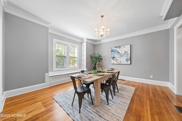 dining space featuring a chandelier, crown molding, and light hardwood / wood-style floors