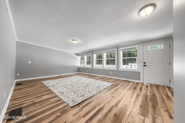 foyer featuring hardwood / wood-style flooring and crown molding