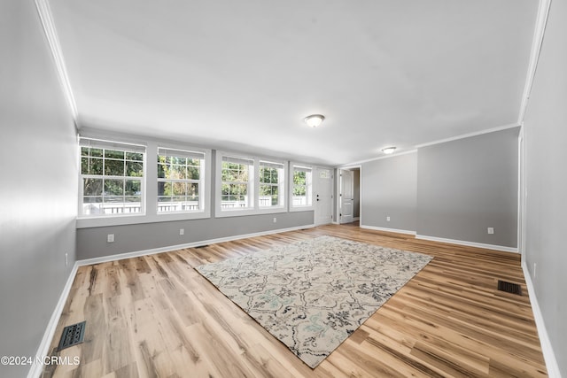 spare room with crown molding and light hardwood / wood-style flooring