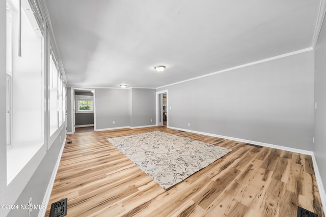 spare room featuring crown molding and light hardwood / wood-style flooring