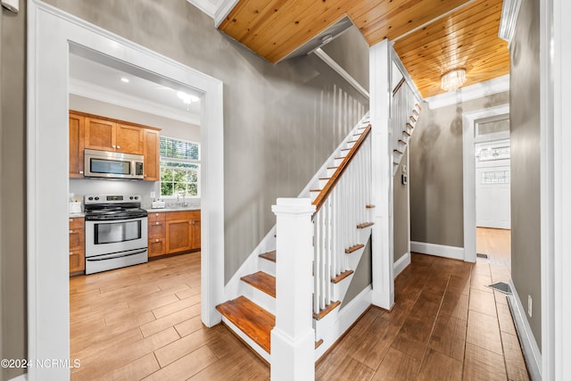 stairway with sink, hardwood / wood-style floors, wood ceiling, and ornamental molding