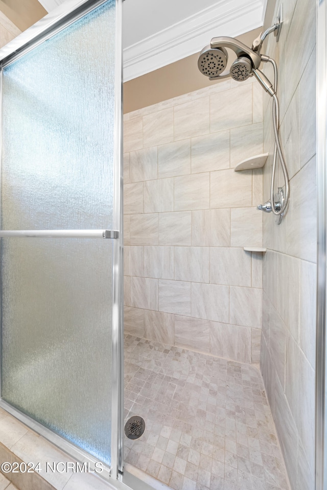 bathroom featuring an enclosed shower and crown molding