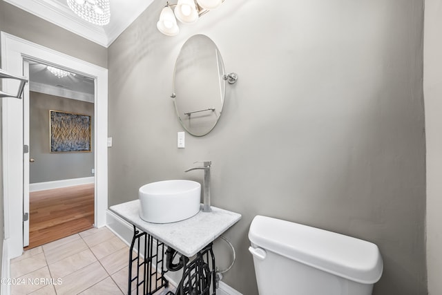 bathroom with tile patterned floors, toilet, sink, and ornamental molding