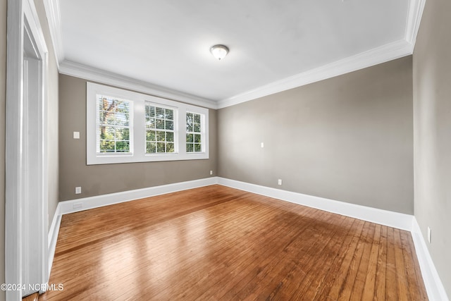 empty room featuring hardwood / wood-style floors and crown molding