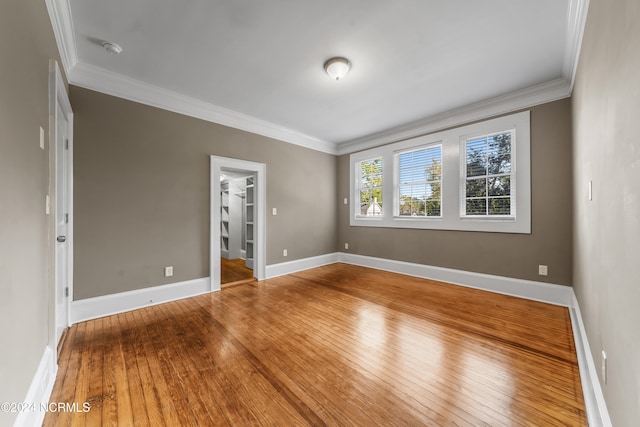 empty room with crown molding and hardwood / wood-style floors