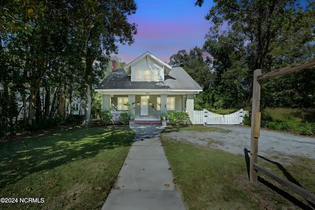 view of front of house featuring a lawn and covered porch