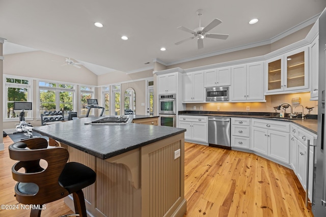 kitchen featuring sink, stainless steel appliances, light hardwood / wood-style floors, lofted ceiling, and white cabinets