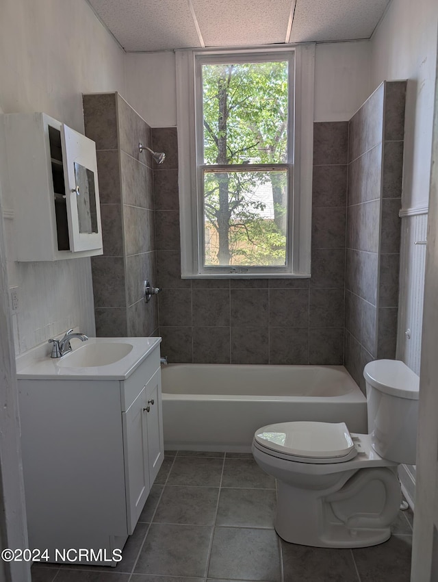 full bathroom with tiled shower / bath, vanity, tile patterned floors, and toilet