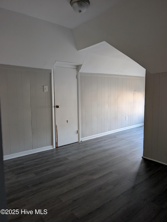 additional living space featuring vaulted ceiling and dark hardwood / wood-style floors