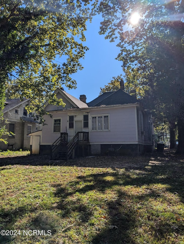 rear view of property featuring a yard