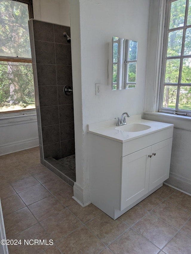 bathroom featuring vanity, tile patterned floors, and tiled shower