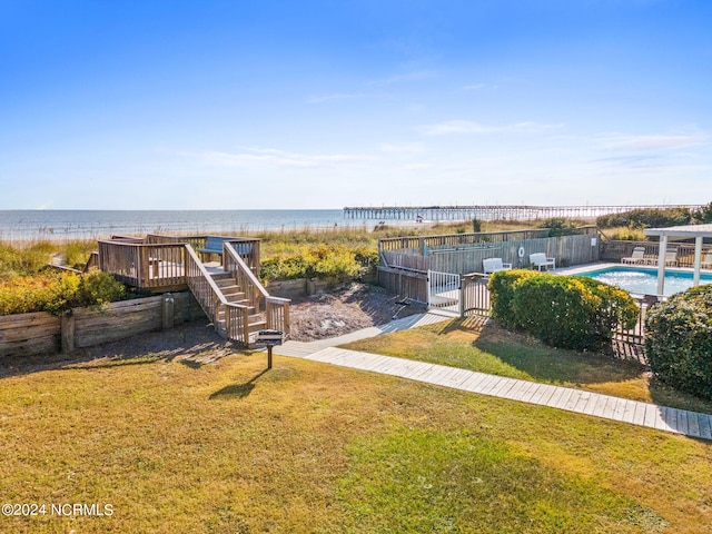 view of yard featuring a swimming pool side deck with water view