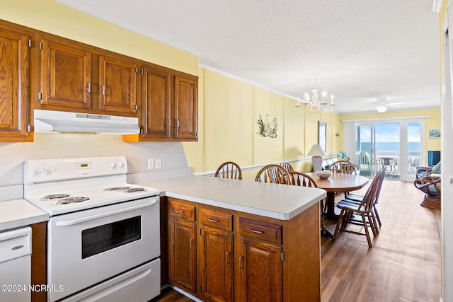 kitchen featuring kitchen peninsula, ornamental molding, dark hardwood / wood-style floors, white electric stove, and ceiling fan with notable chandelier