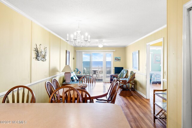 dining room with crown molding, a textured ceiling, hardwood / wood-style flooring, and ceiling fan