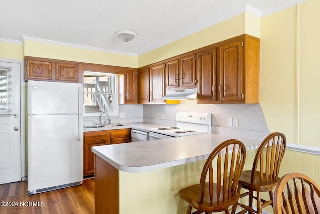 kitchen with white appliances, ornamental molding, sink, and kitchen peninsula