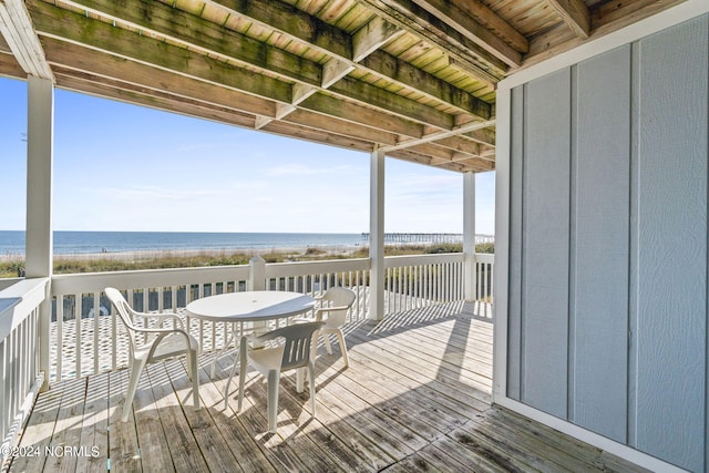 wooden deck featuring a view of the beach and a water view