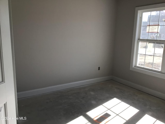 unfurnished room with a healthy amount of sunlight and concrete floors