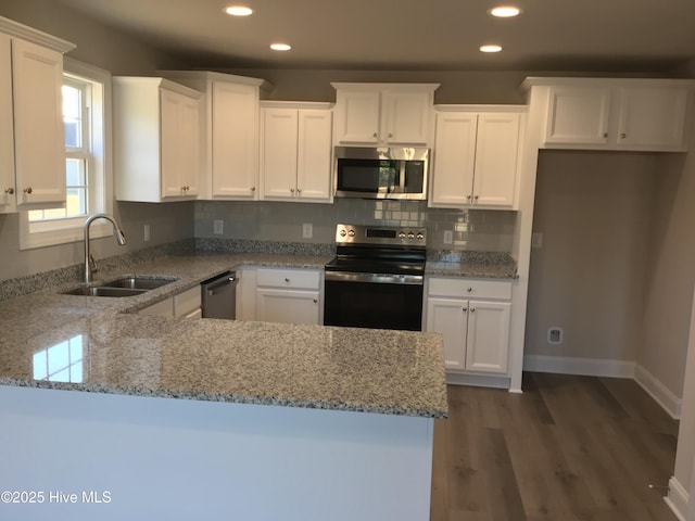 kitchen featuring light stone countertops, white cabinetry, appliances with stainless steel finishes, and sink